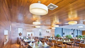 Un restaurante espacioso con suelo de madera y mesas dispuestas para comer.