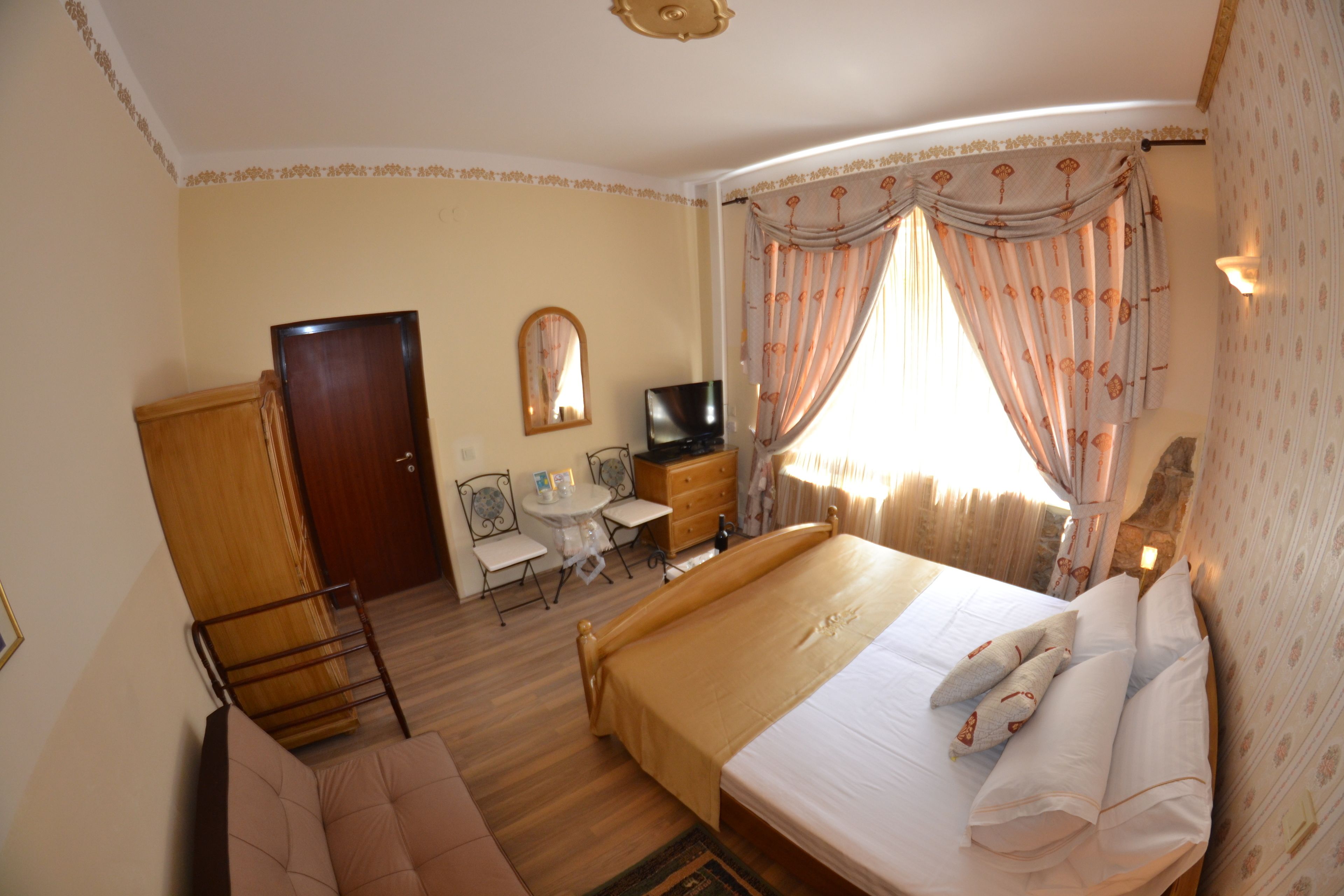 Une chambre d’hôtel avec un lit, une télévision, un bureau et une chaise.