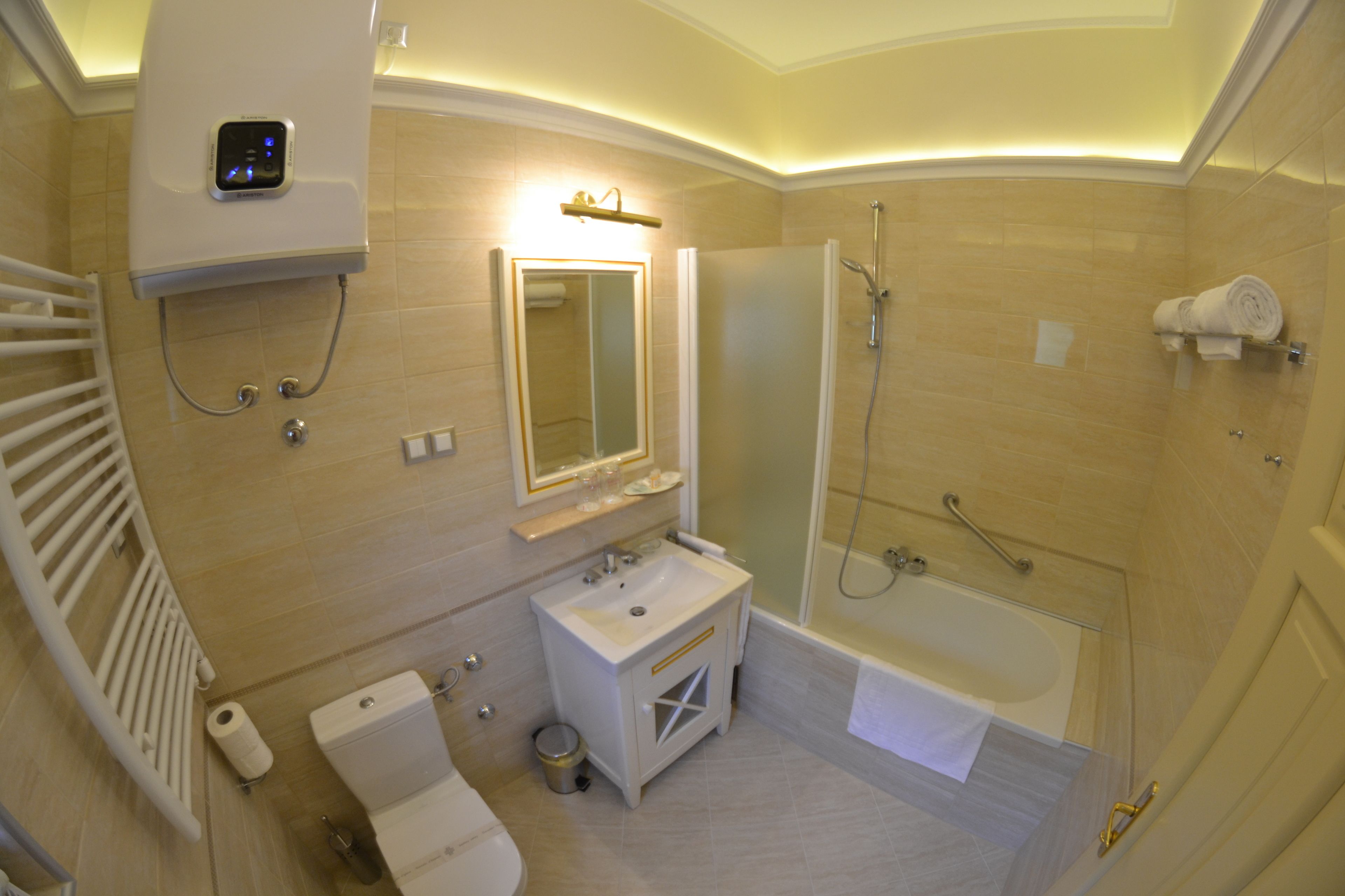 A modern bathroom with a toilet, sink, mirror, shower, and towel rack.