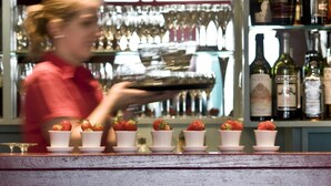 A bar area with shelves of wine bottles and glasses. - De Laurier (Knokke-Heist)