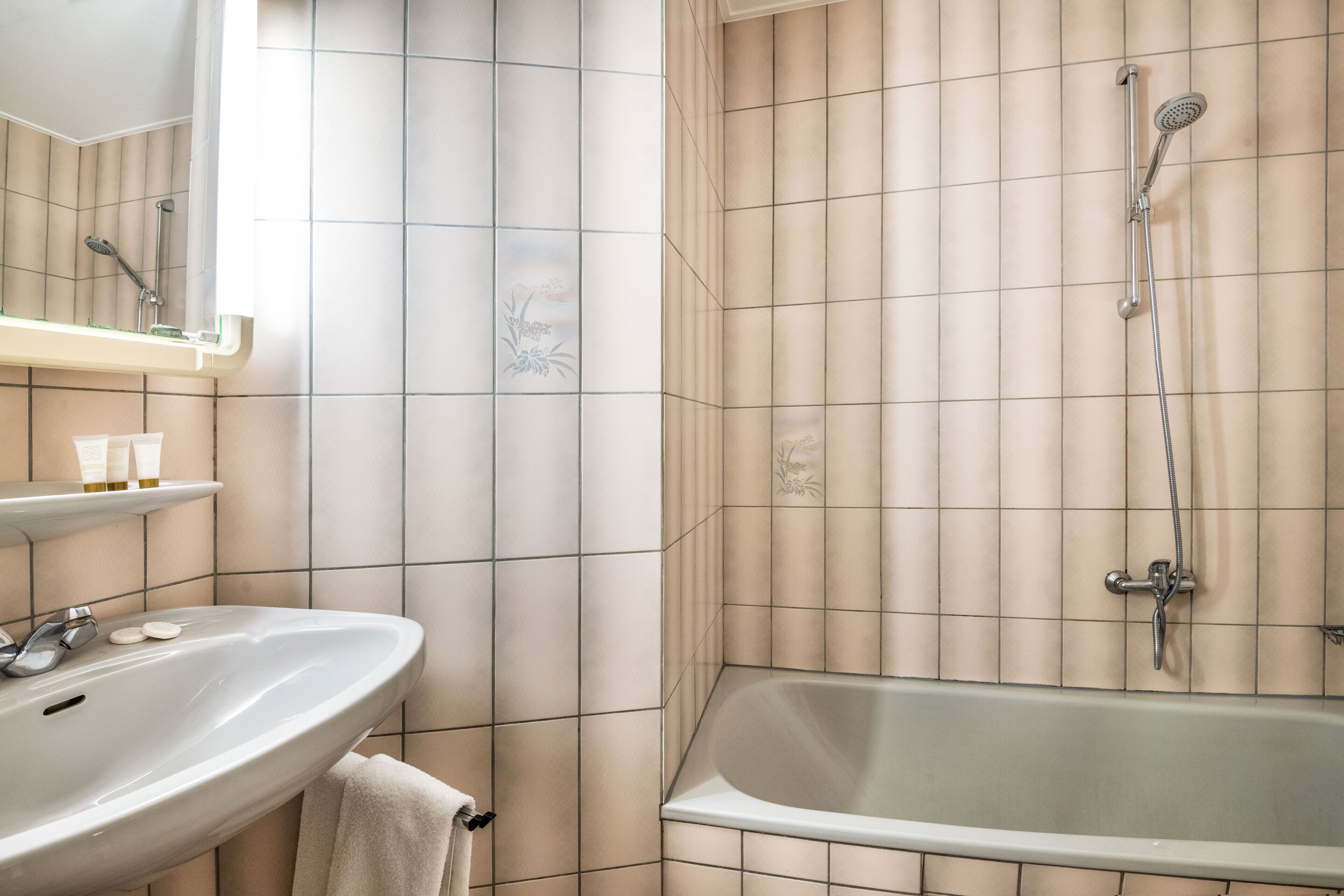 Un baño con lavabo, espejo y ducha.