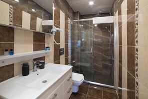 Habitación triple de lujo | Baño | Regadera, amenidades de baño gratuitas, secadora de cabello, pantuflas 