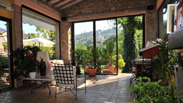 An outdoor patio with a table, chairs, and potted plants. - Relais San Bruno (Montepulciano)