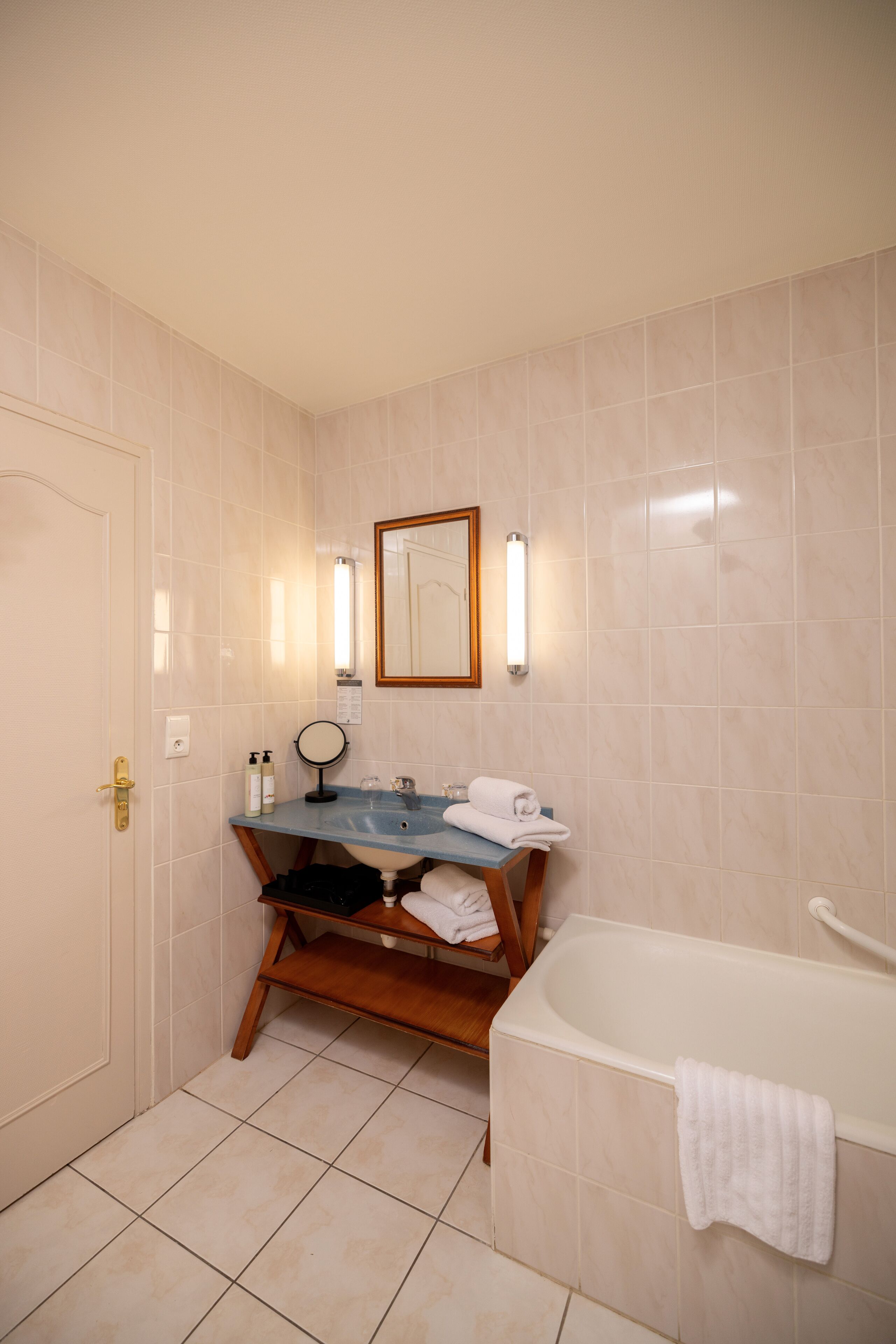A bathroom with a bathtub, a sink with a mirror, and a towel rack.