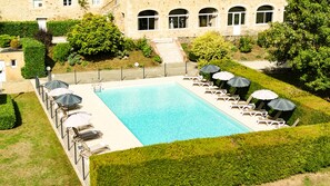 Una piscina al aire libre de temporada, sombrillas