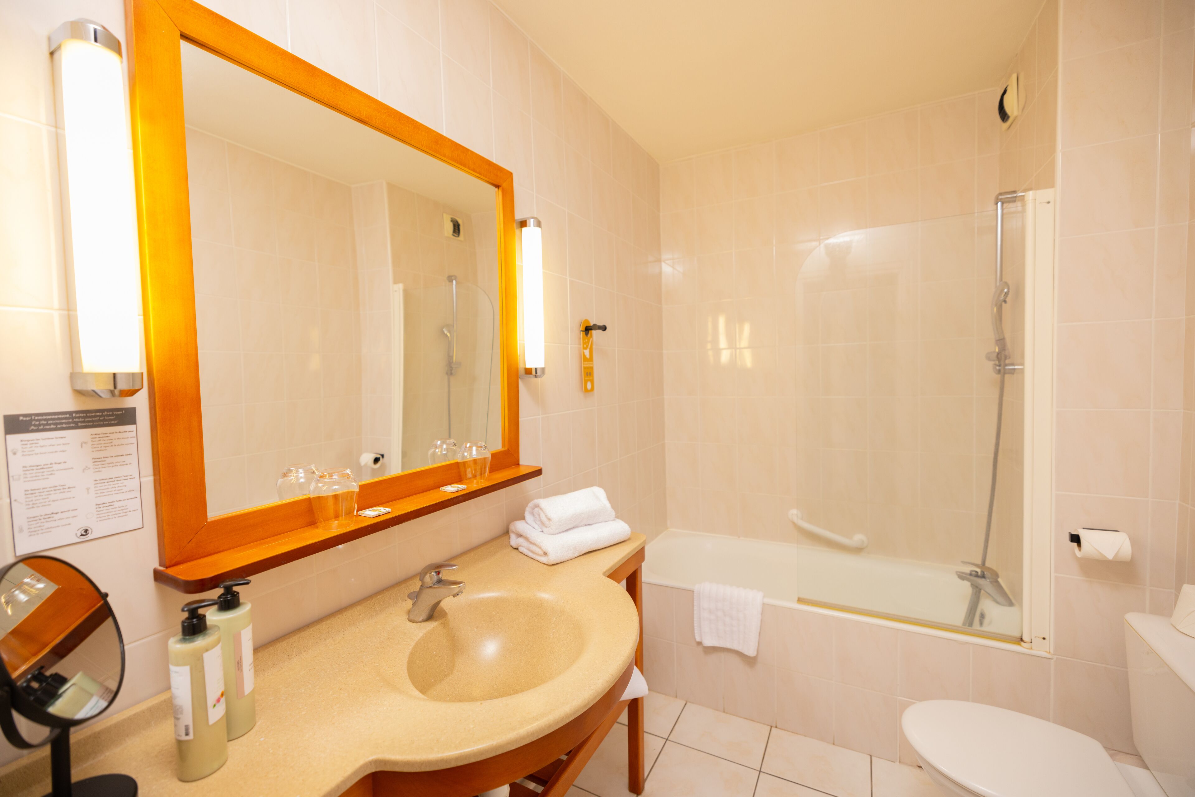 A bathroom with a sink, mirror, and a bathtub.