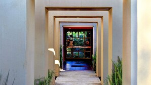 Un sendero de madera que conduce a una puerta con un vitral.