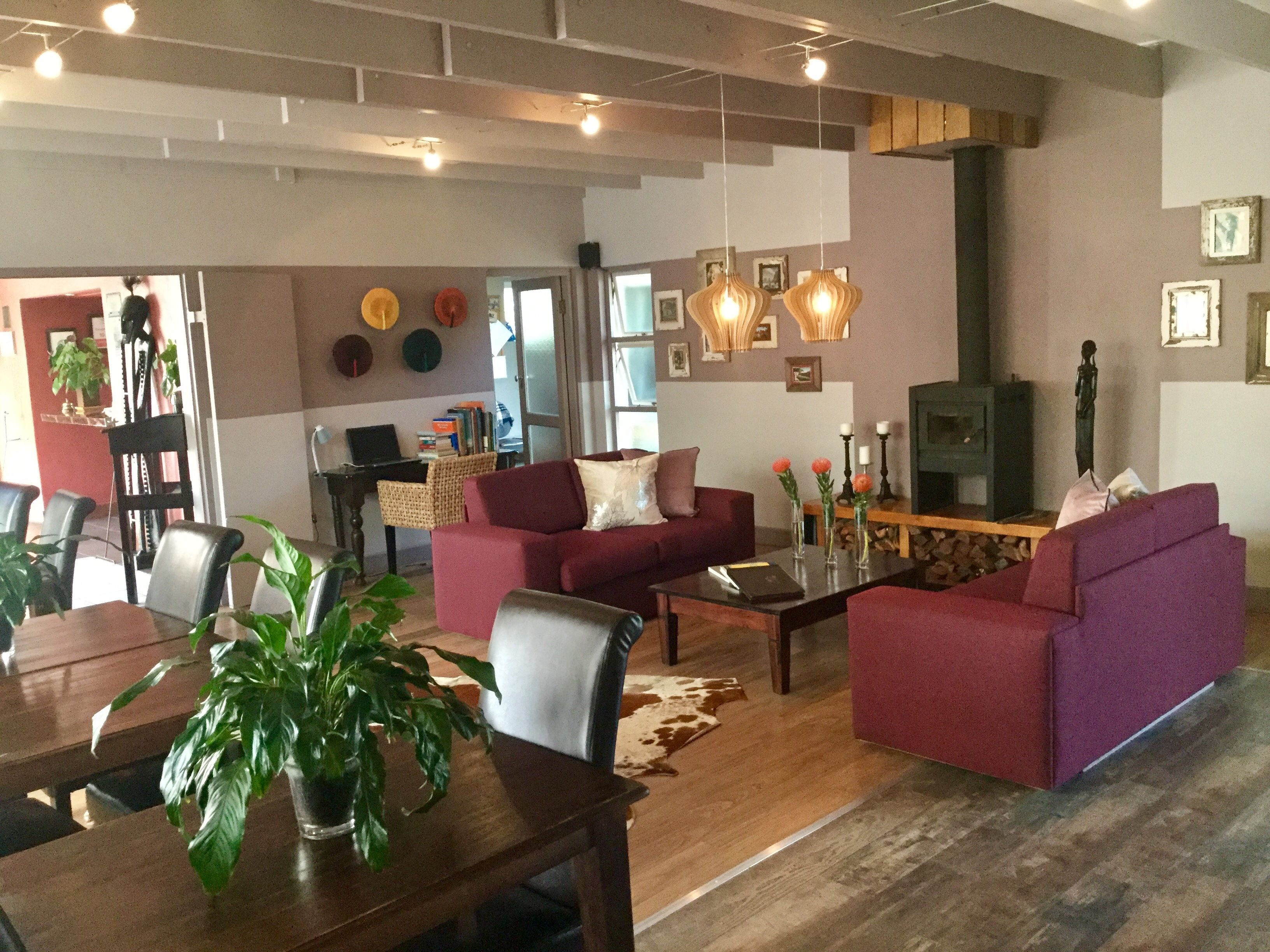 A modern living room with a fireplace, a dining area with a table and chairs, and a seating area with sofas.