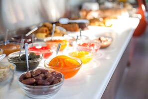Un bufé con diversos alimentos y utensilios.