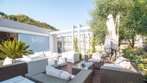 En poolbar kaldet Delizia med udendørs siddepladser og udsigt over det grønne omkringliggende landskab.