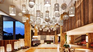 A spacious lobby with multiple hanging light fixtures, a reception desk, and a staircase leading to upper floors. - Four Points By Sheraton Bali, Kuta (Kuta)