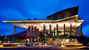 A modern hotel with a unique architectural design, featuring a large overhanging roof and multiple columns. - Four Points By Sheraton Bali, Kuta (Kuta)