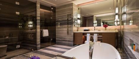 A modern bathroom with a freestanding bathtub, a glass shower enclosure, and a vanity with a large mirror.