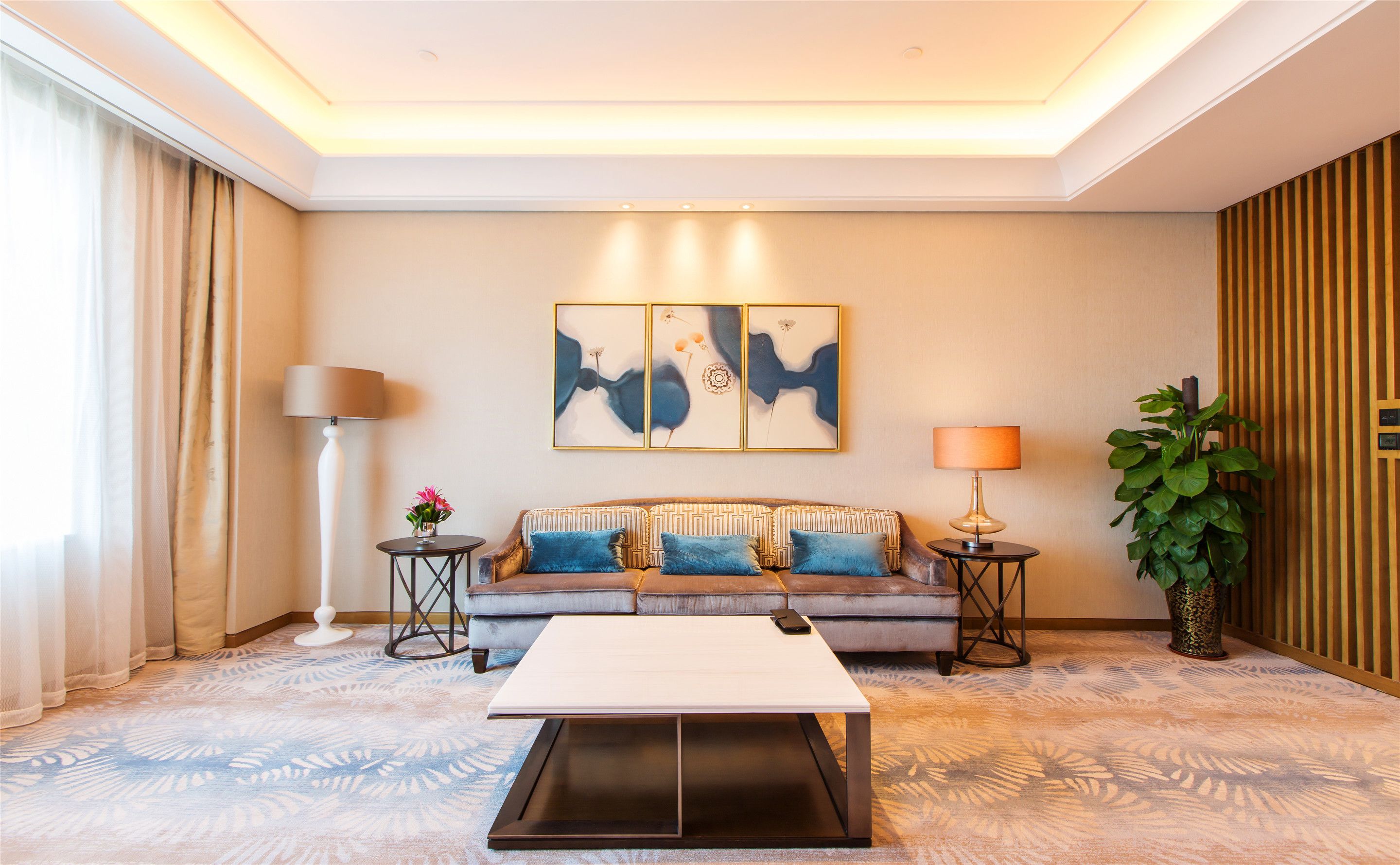 A modern living room with a sofa, coffee table, and decorative lamps.