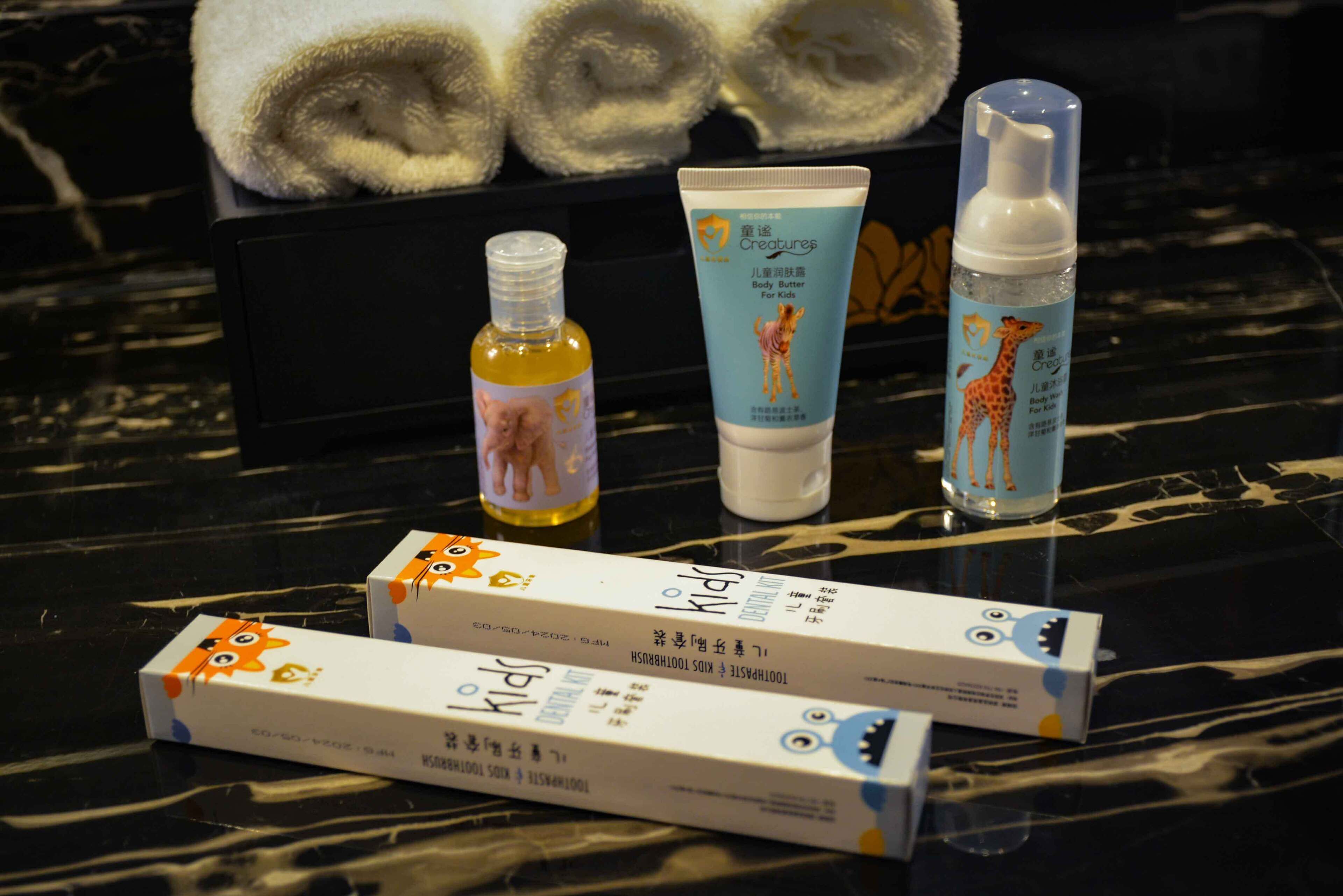 A table with skincare products, including a tube of body butter and a bottle of lotion, alongside two boxes of skincare items.