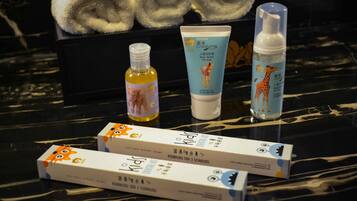 A table with skincare products, including a tube of body butter and a bottle of lotion, alongside two boxes of skincare items.