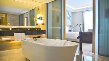 A modern bathroom with a freestanding bathtub, a large mirror, and a glass shower enclosure.