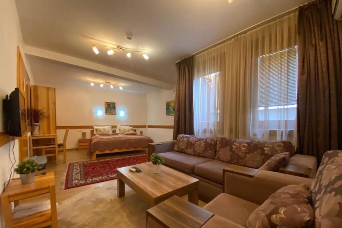 A modern living room with a sofa, coffee table, and a TV mounted on the wall.