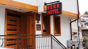 Un hôtel appelé « BERR HOTEL », avec des portes en bois et une enseigne.