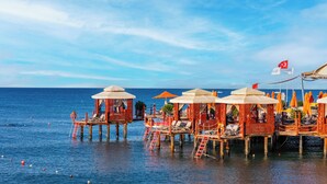 A seaside resort with wooden overwater bungalows, each featuring a covered seating area and a view of the ocean. - VONRESORT Golden Coast - All Inclusive (Manavgat)
