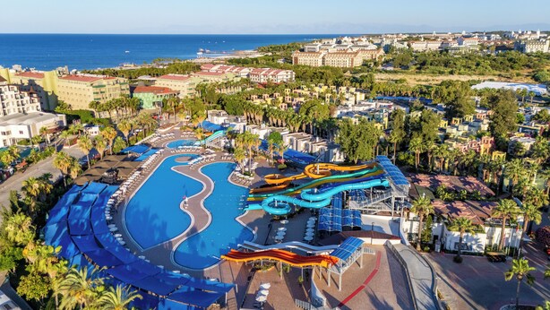 A resort with a large swimming pool, water slides, and a view of the sea. - VONRESORT Golden Coast - All Inclusive (Manavgat)
