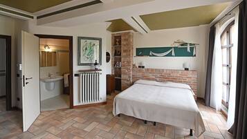 Un dormitorio con cama, un baño con lavamanos y una pared de ladrillo.