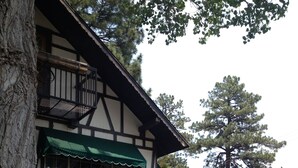 Un bâtiment traditionnel doté d’un balcon et de deux fauteuils Adirondack placés devant.
