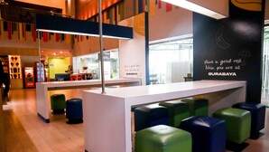 A reception area with a counter, seating area with colorful stools, and a wall with a motivational quote.
