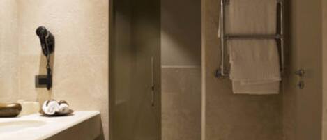 A modern bathroom with a large mirror, a sink, and a towel rack.