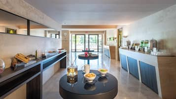 Una cocina moderna con una isla central, un comedor y vistas al área de la piscina exterior.
