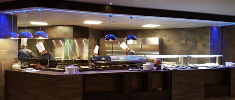 Una cocina moderna con electrodomésticos de acero inoxidable y detalles de iluminación azul.
