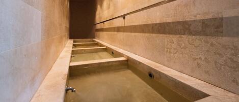 A modern bathroom with a built-in bathtub, a shower area, and a tiled floor.