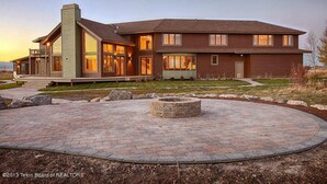 A two-story house with a large patio area and a fire pit. - Dreamcatcher Bed and Breakfast (Victor)