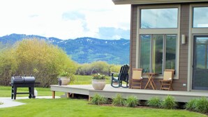A modern house with a covered patio, outdoor seating, and a barbecue grill. - Dreamcatcher Bed and Breakfast (Victor)