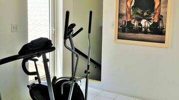 A home gym with exercise equipment, a treadmill, and a weight bench.