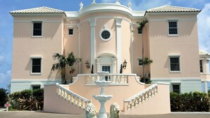 Un edificio con una fuente que presenta estatuas de leones, una escalera y cielo despejado.