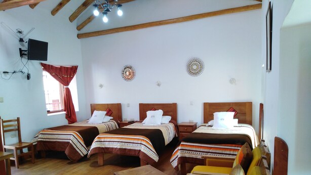 Habitación de hotel con dos camas, muebles de madera y una televisión.