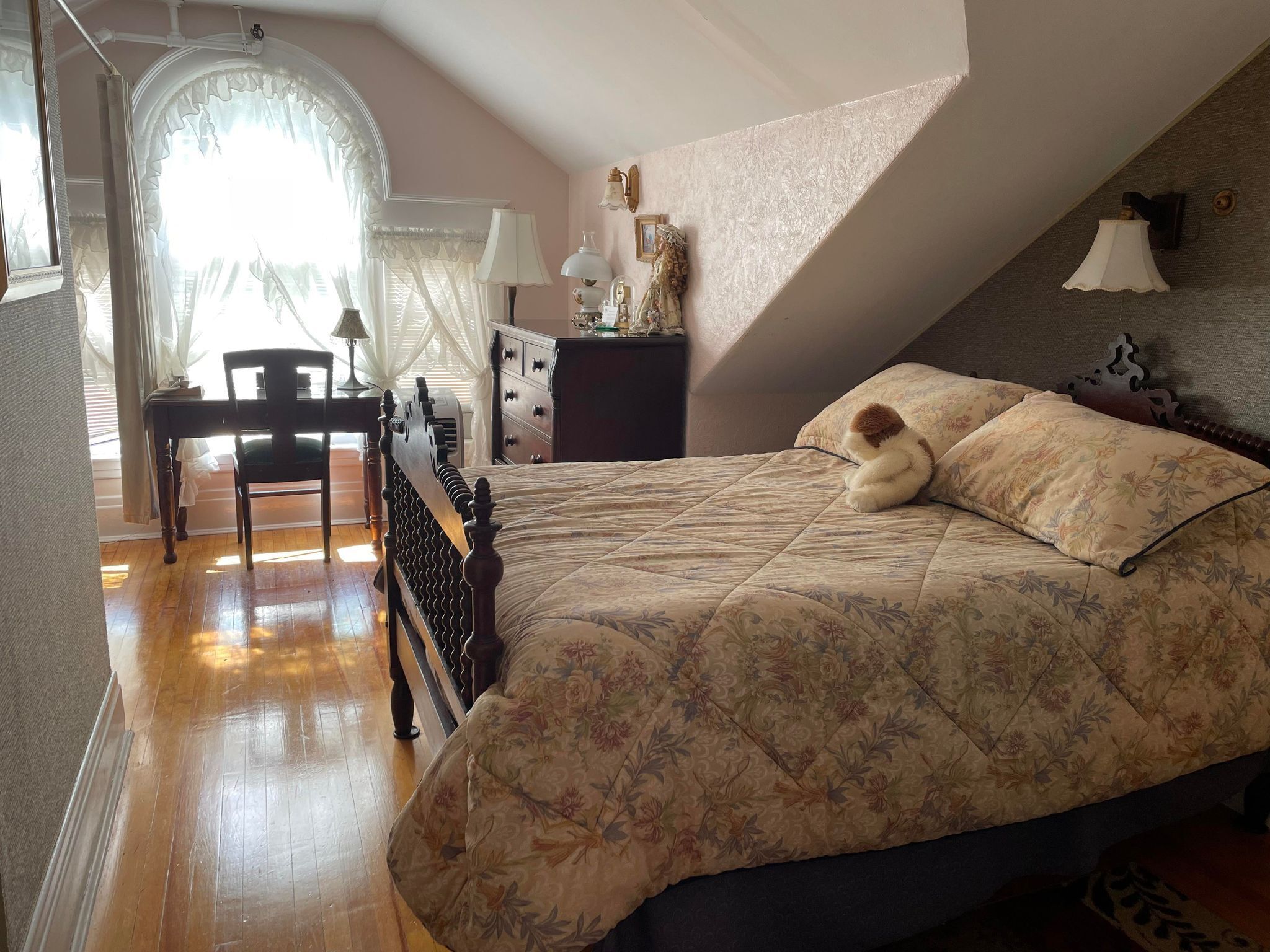 Un dormitorio con cama, escritorio y silla.