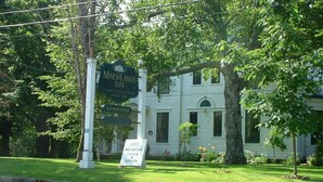 A historic building with a sign indicating it is a restaurant. - Marshlands Inn (Sackville)