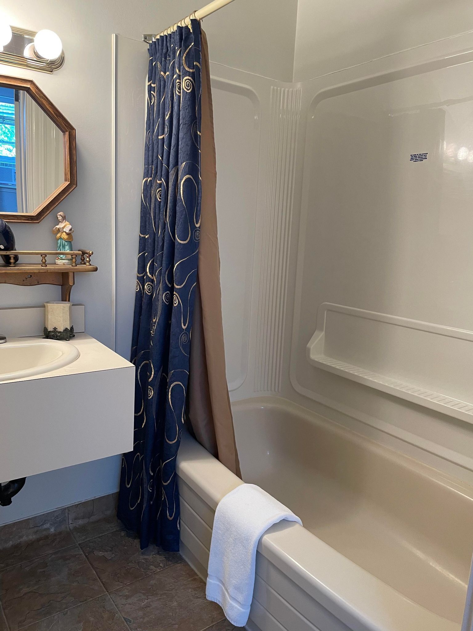 A bathroom with a bathtub, a sink, a mirror, and a shower curtain.