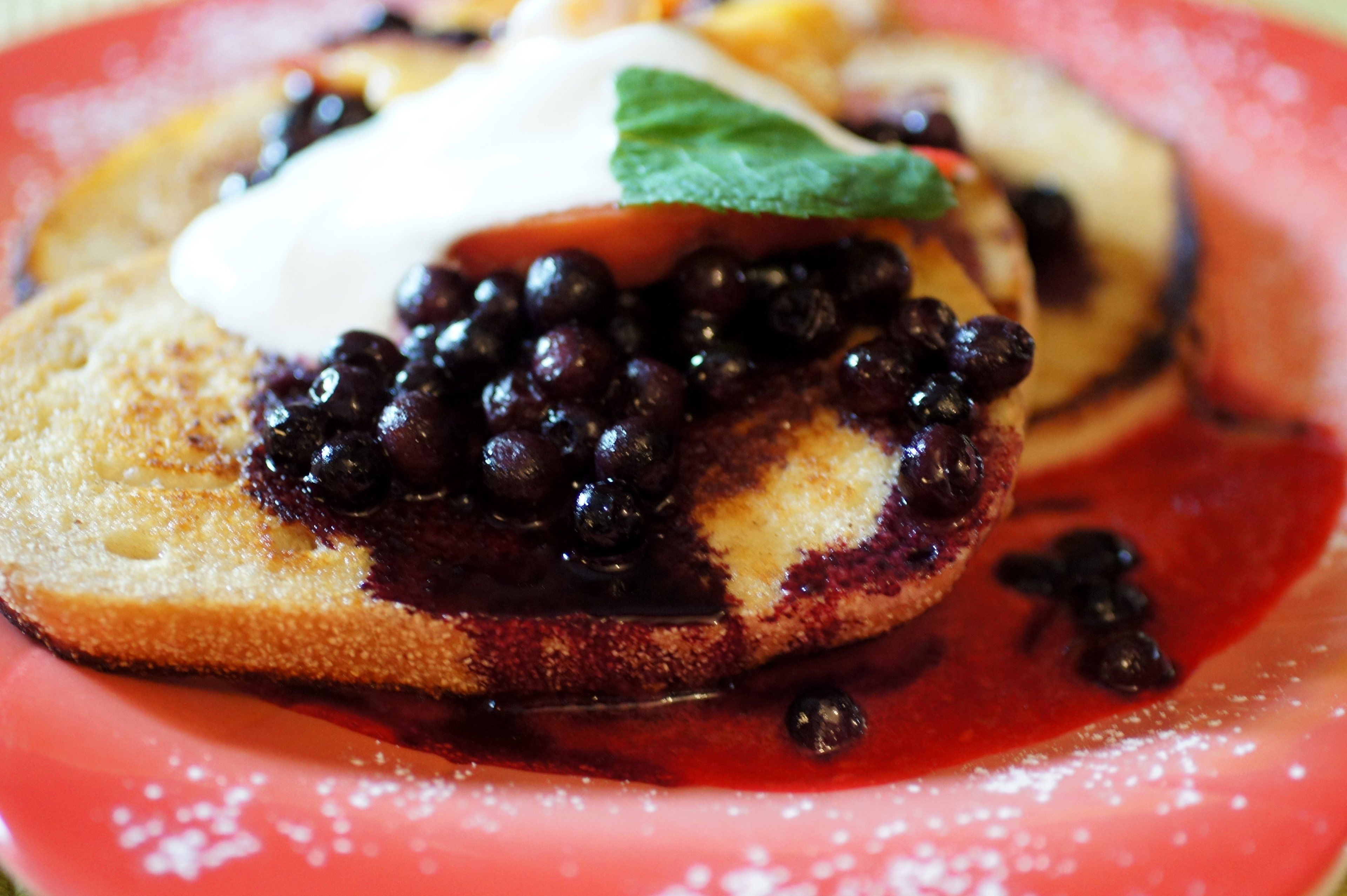 A dessert with a slice of cake topped with berries and a dollop of cream.