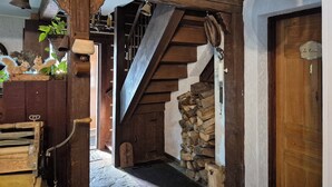 Un interior rústico con una escalera de madera, una campana y una puerta con la leyenda 'La Poésie'.