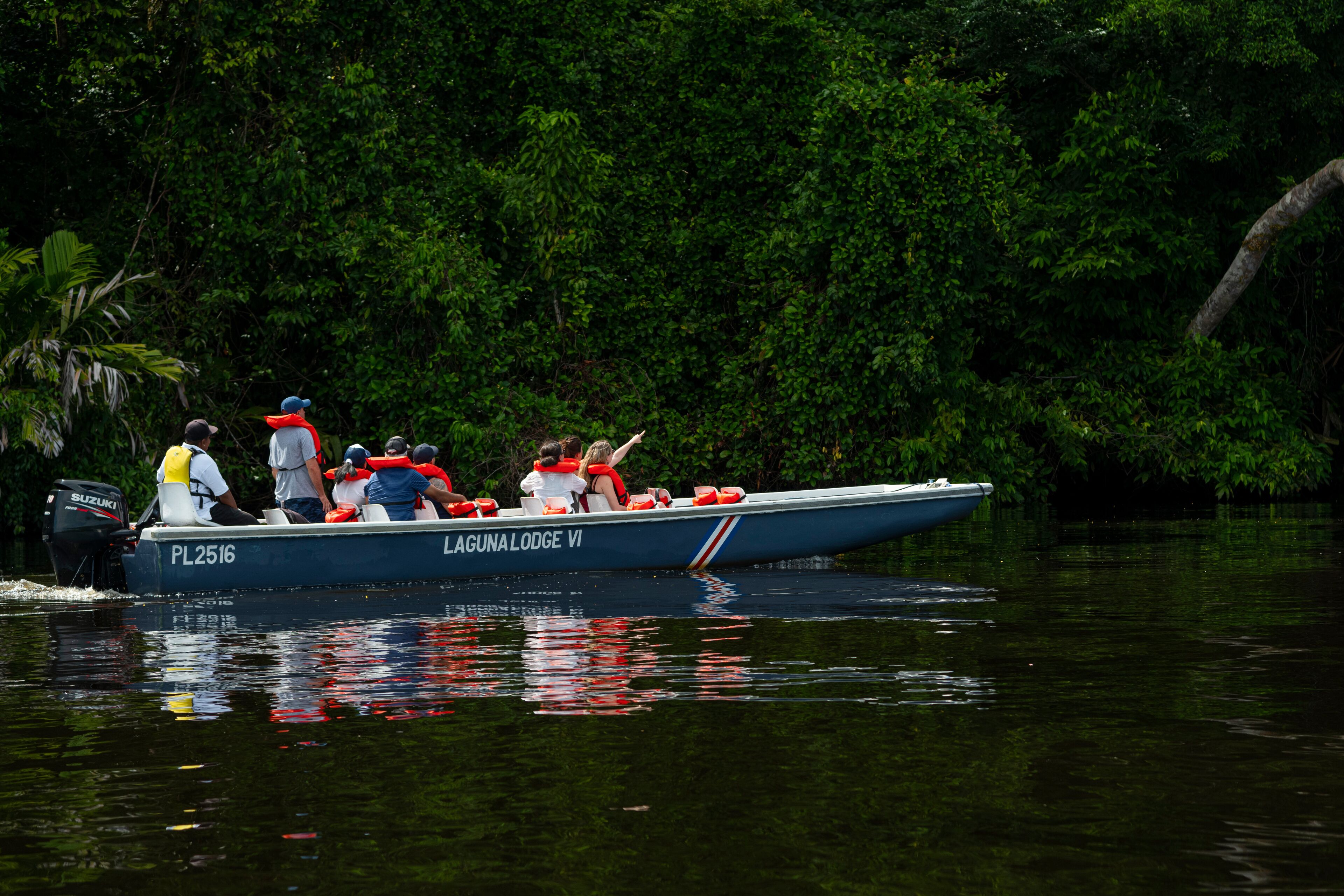 A boat named PL2516 with the text "LAGUNA LODGE VI" on its side, surrounded by dense green foliage.