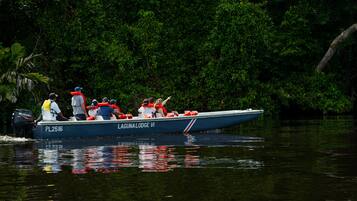 A boat named PL2516 with the text "LAGUNA LODGE VI" on its side, surrounded by dense green foliage.