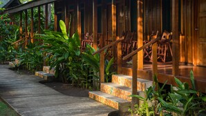 A wooden staircase leading to a covered porch with chairs. - Laguna Lodge (Colorado)