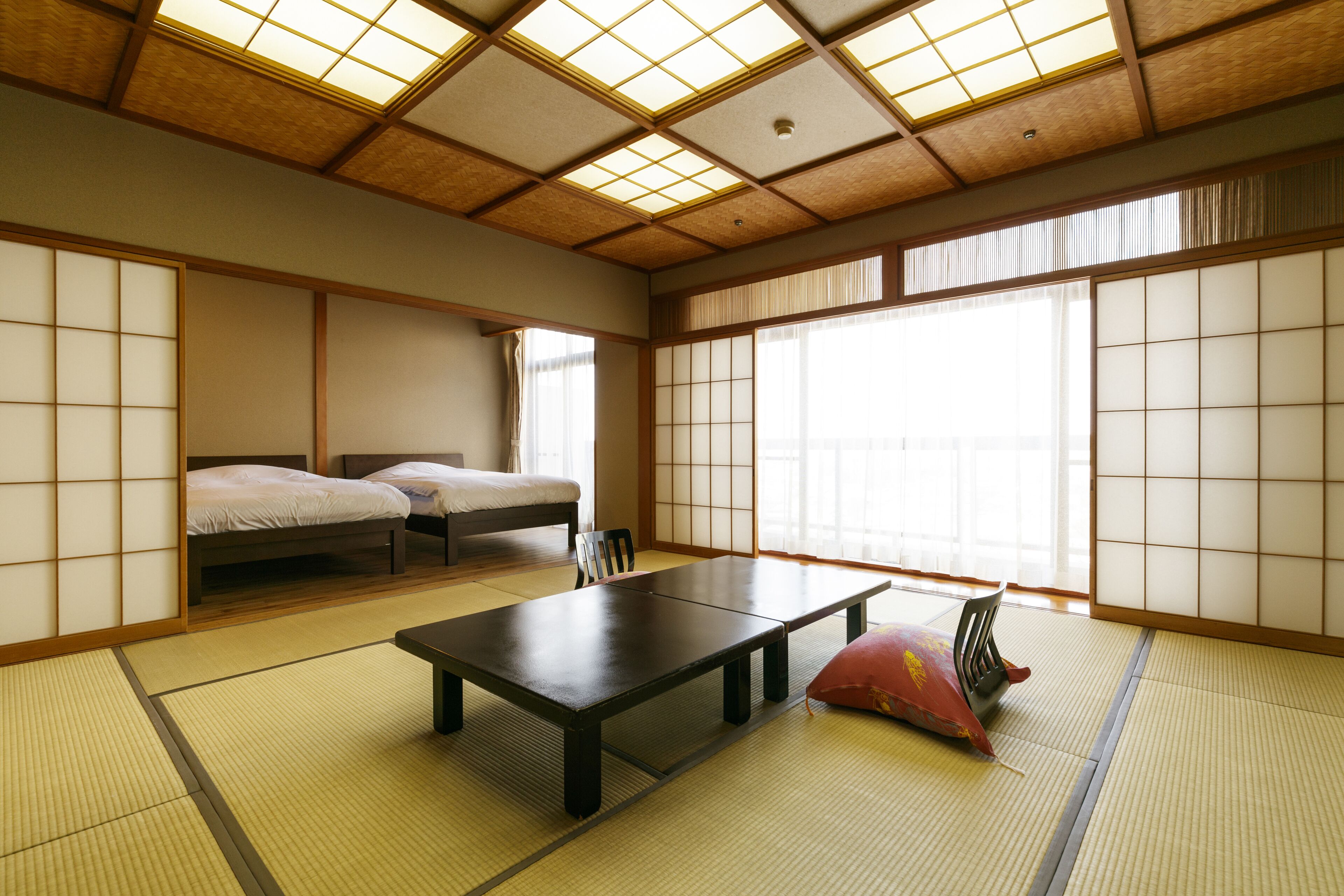 A traditional Japanese room with tatami flooring, a low table, and a futon bed.