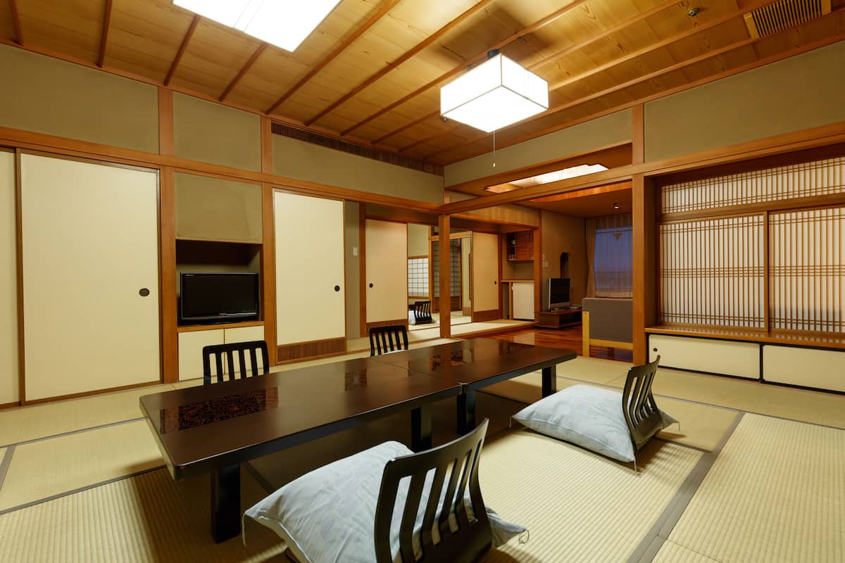 Ett traditionellt japanskt rum med tatamimattor på golvet, ett lågt bord och skjutdörrar.