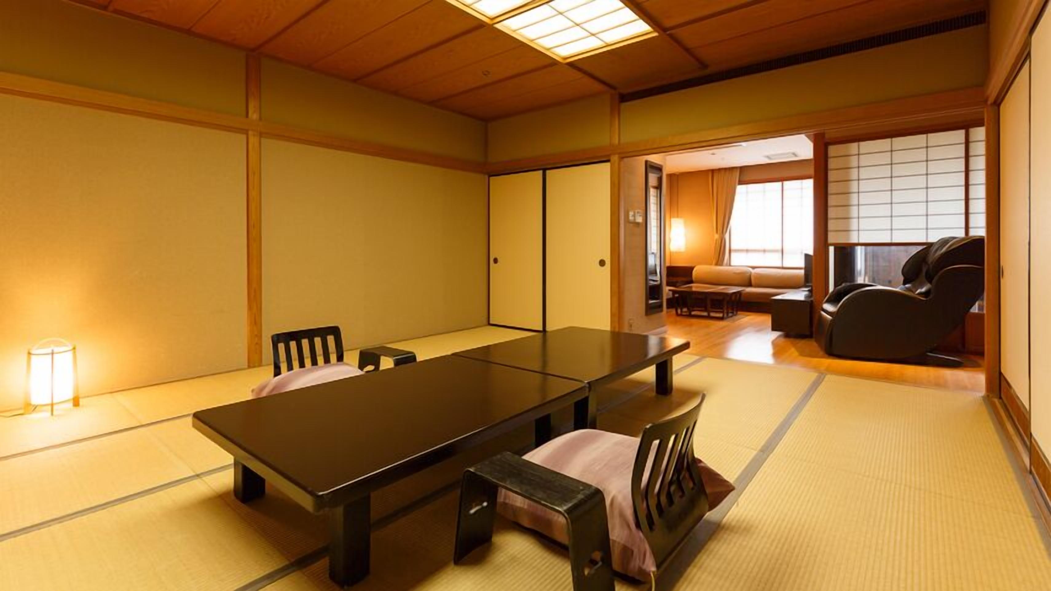 A traditional Japanese room with tatami flooring, a low table, chairs, a sofa, and a massage chair.