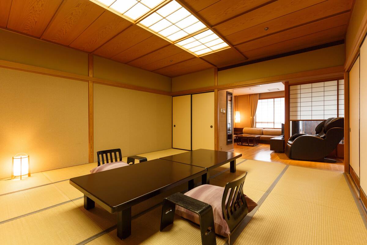 Ett traditionellt japanskt rum med tatamimattor på golvet, ett lågt bord och sittplatser.