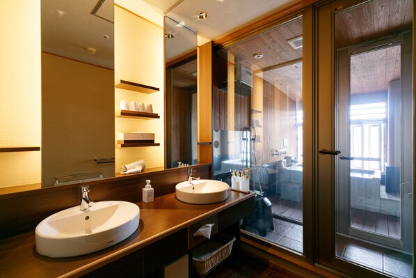 A modern bathroom with two sinks, a large mirror, and a view of a wooden deck outside. - Rurikoh (Kaga)